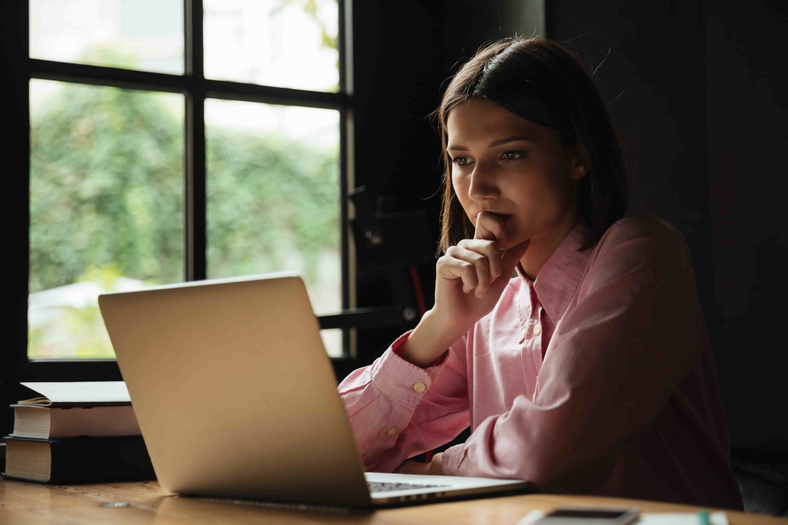 Mulher pesquisa no notebook como aparecer no ChatGPT em ambiente de trabalho