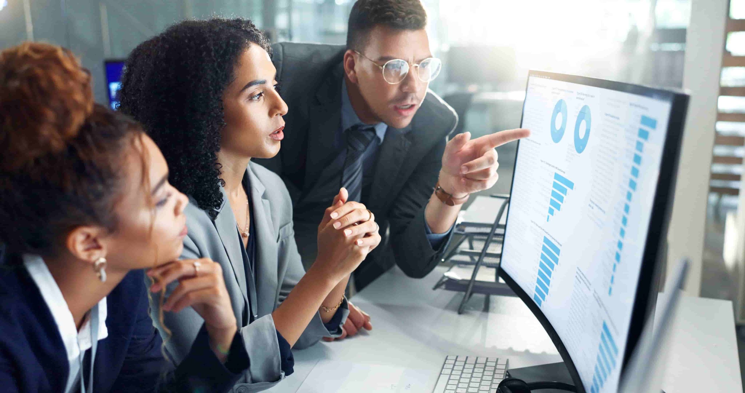 Equipe analisa dados de geração de leads em monitor durante reunião estratégica